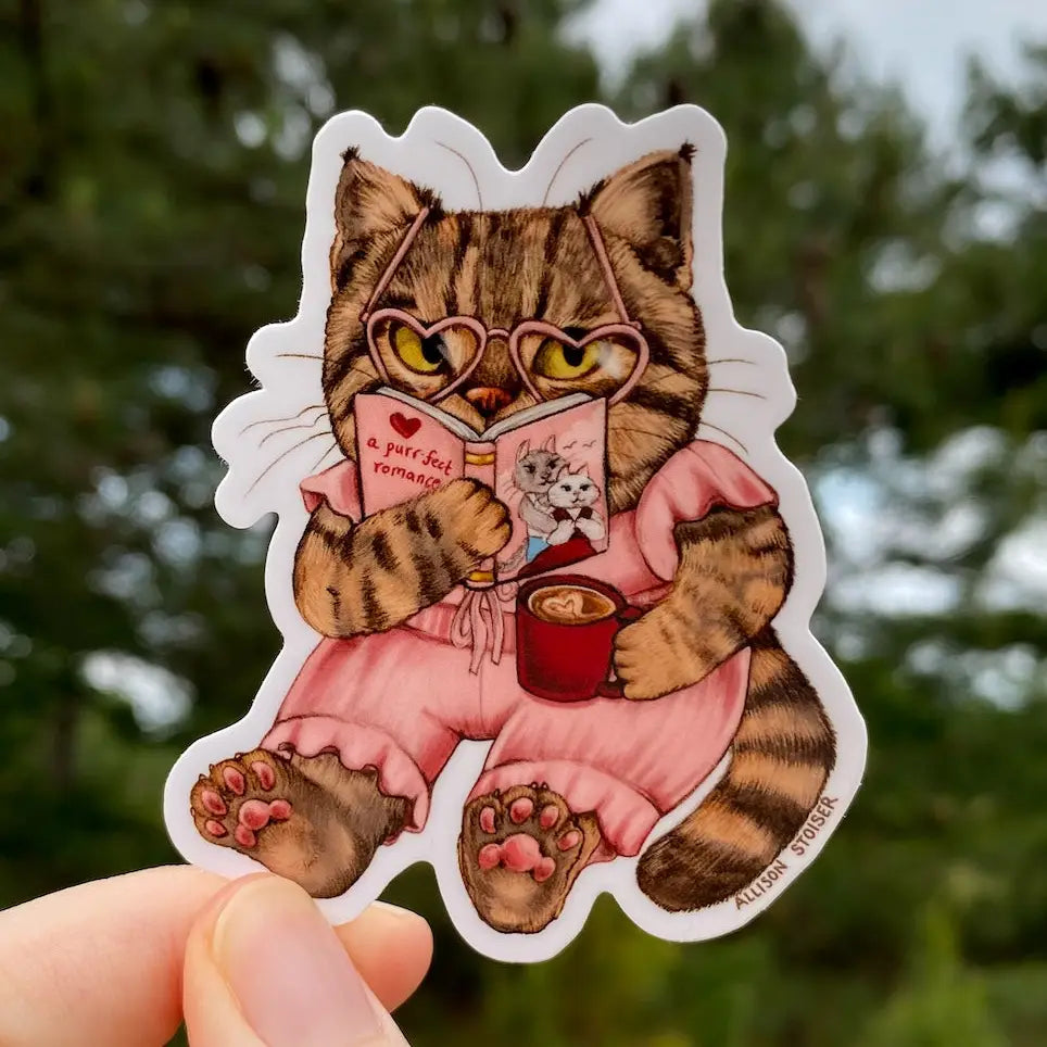 Allison Stoiser Art - Romance-Loving Bookish Tabby Cat Vinyl Sticker
What's better than cozying up with your favorite toasty beverage and the purr-fect romance novel? Absolutely nothing, according to this tabby cat!