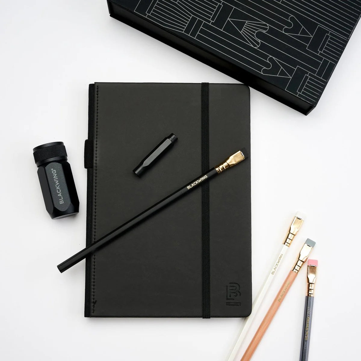 A great way to get started on the Blackwing journey. Give the gift of high-quality Blackwing pencils, paper & accessories — all in one box set.
Includes a Medium Black A5 Slate Notebook, each of our core pencils (602, Matte, Pearl, Natural), One-Step Long Point Sharpener, and Point Guard -- all packaged in a box set.