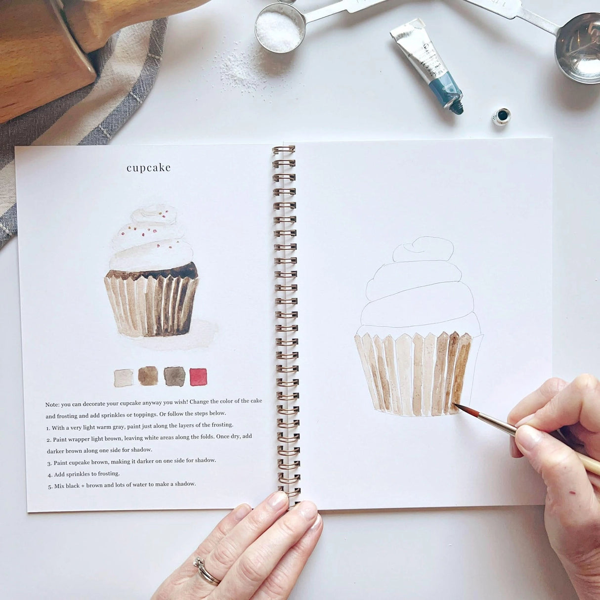 Emily Lex Studio Watercolor Workbook - Baking
Twelve baking illustrations — a cupcake, layer cake, mixing bowl, lattice pie, tray of cookies, rolling pin with cookie cutters, and more — each pre-outlined with step-by-step instructions. Paintings take about thirty minutes from start to finish, making it approachable for first-time painters and a favorite for gifting.
12 beginner-friendly illustrations
Thick 120lb watercolor paper
Lay-flat pages with spiral binding for hassle-free painting and easy te