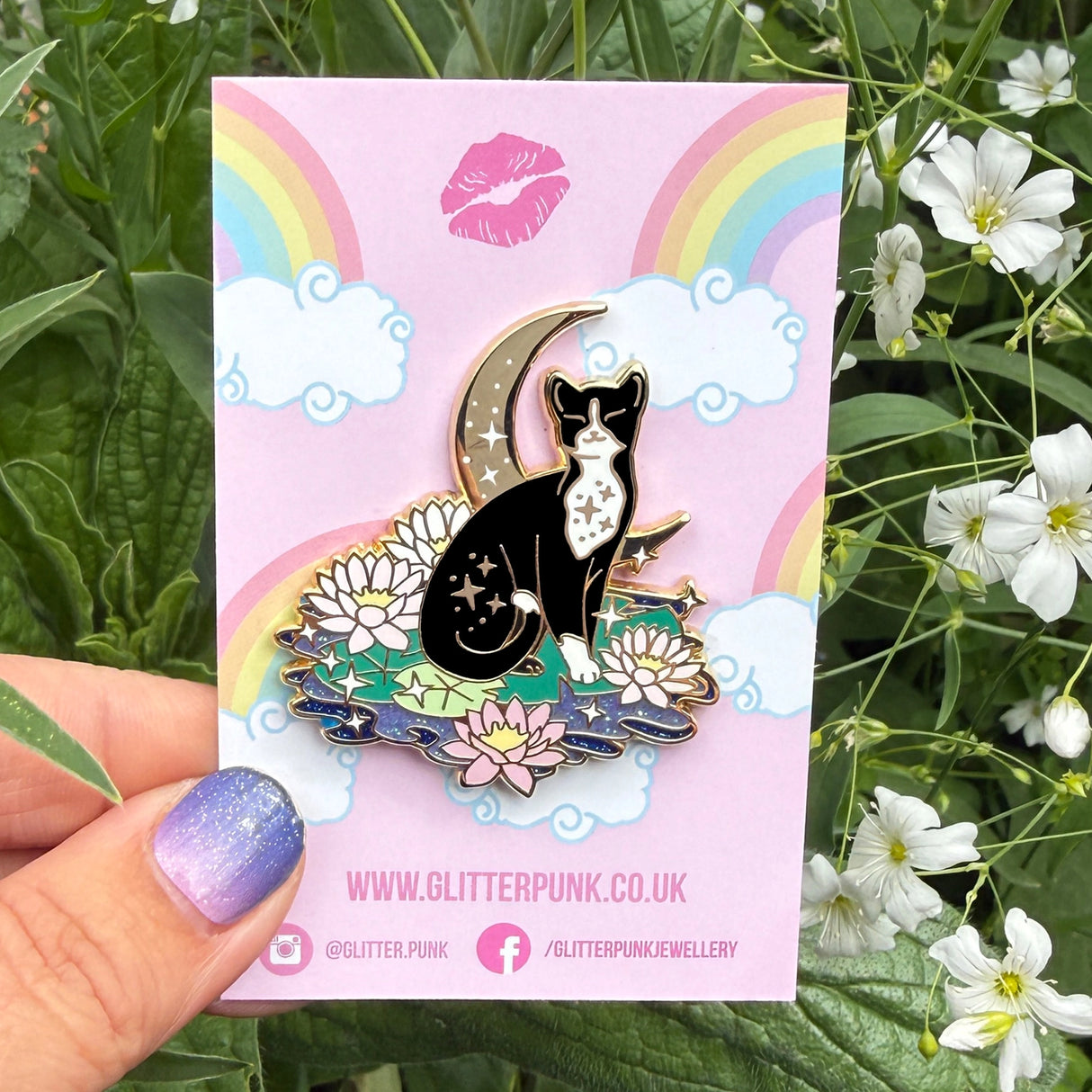 This super sweet fantasy pin features a black and white tuxedo cat relaxing on a lily pad in front of a crescent moon.
It’s 45mm (1.77”) wide, and is made from gunmetal hard enamel, with glitter and UV printed details. It's secured with 2 pink clutches to keep the pin in place.