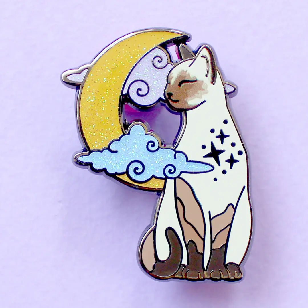 Glitter Punk - Pointed Cat Enamel Pin
Affectionate, clever and loud - there's no feline with the personality quite like a pointed cat!
This super sweet enamel pin depicts a pointed cat in a relaxed moment, in front of a glittery moon and clouds.