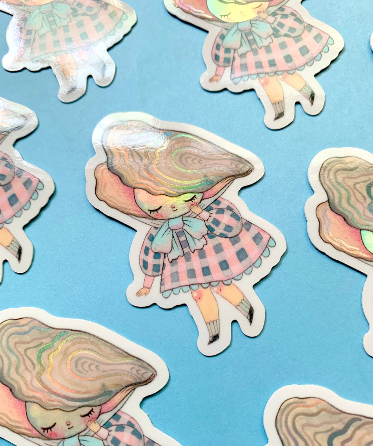 "Pearl" Vinyl Sticker made from Hannakin illustration with subtle holographic accents (on the face and oyster shell) with shiny gloss finish.
Made from a durable waterproof vinyl with a matte laminate that protects it from scratching, rain and sunlight.