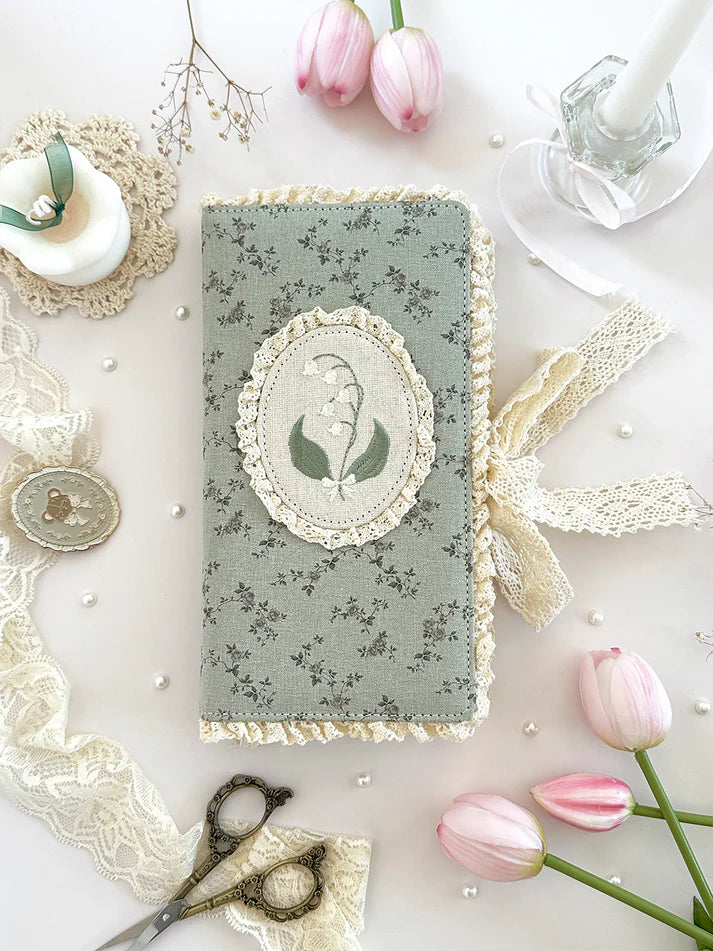 lily of the valley fabric notebook cover. sewn together with careful craftsmanship. lined with lace ruffles for that extra romantic, cottage-core, fairytale touch. meant to protect your notebooks & a keepsake for your beloved stationery :)
♡ floral linen pattern with ruffle lace edging & lily of the valley embroidery
♡ lace ribbon enclosure to help keep your notebooks closed
♡ 7 pockets total (left sleeve: 5 pockets | right sleeve: 2 pockets)
♡ x1 lace ribbon book mark with gold bow pendant