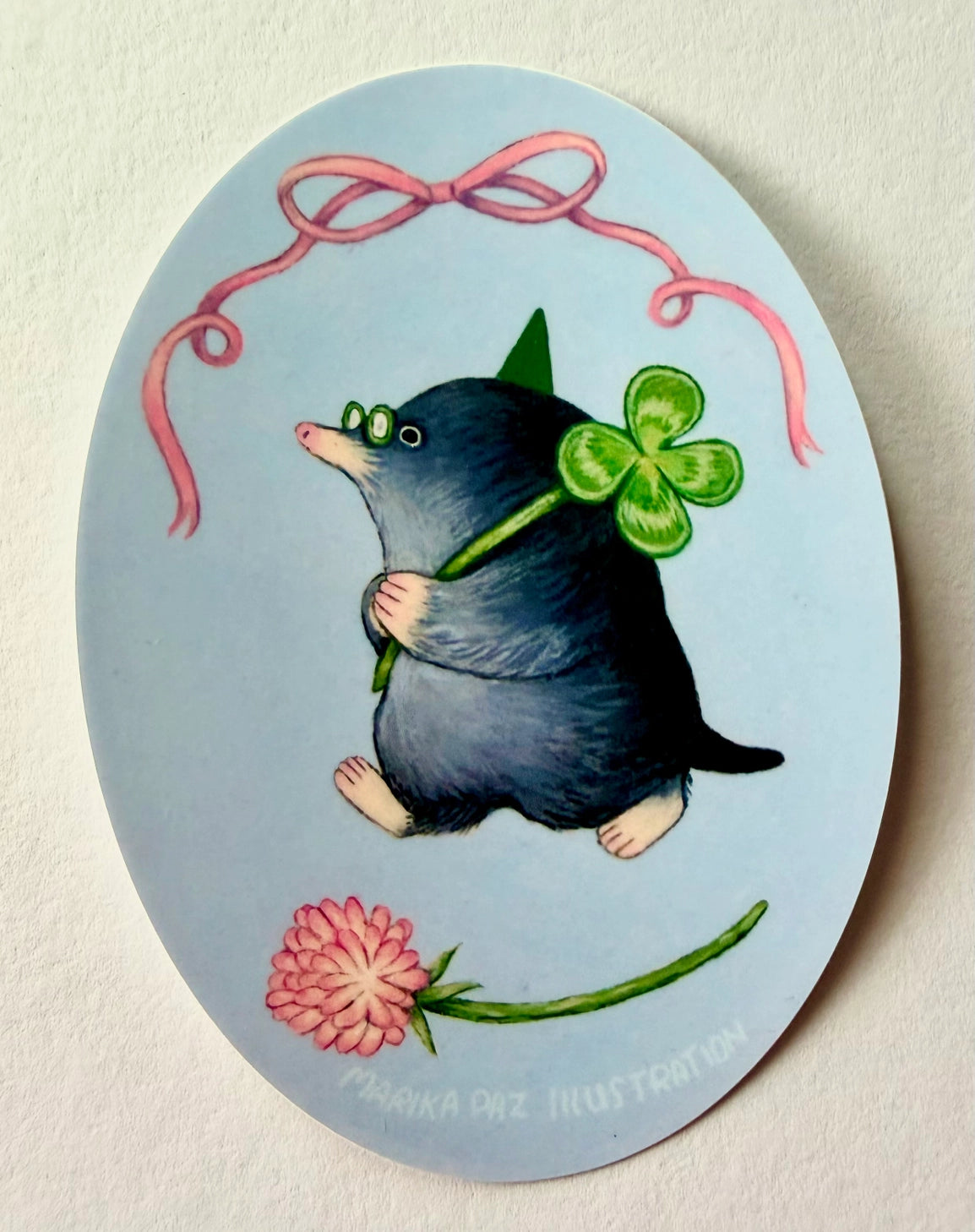A very lucky mole takes their four-leaf clover home.
This vinyl matte sticker is weather and waterproof-stick it on a notebook, bike, or car- it's going to stick around! Heck, throw it on a water bottle and through the dishwasher. This sticker can go anywhere. Sticker measures 3.25" x 4.5" Printed in USA.
