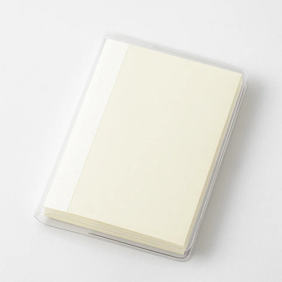 A transparent cover that fits snugly around your MD Notebook
This is a special cover that gently wraps your MD Notebook. The transparent cover protects the notebook from dirt without ruining its appearance.
It subtly protects your notebook from water and dirt without interfering with its characteristics. If you put the cover on with the glassine paper still wrapped around it, the inorganic feel of the vinyl will be softened.
Because it is transparent, you can enjoy the cover design, illustrations, and writ