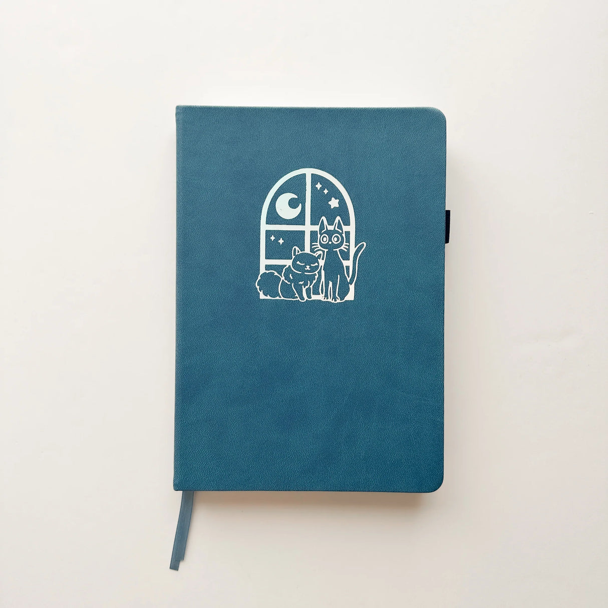 Jiji The Cat Journal in Ocean Blue with Holographic Edges and Logo 🌊✨
Product Details:
Size: A5 (5.70 x 8.26 inches)
160 Dotted Grid Pages (5 x 5 mm)
2 Bookmarks
Elastic Band and Pen Holder
Expandable storage compartment