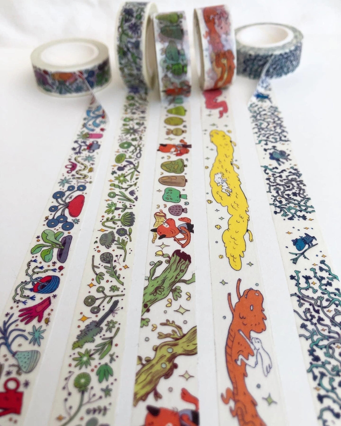 This Dragon washi tape features three soft, fluffy dragons that the dragon rider girl has befriended.
This roll is 15mm wide x 10m of paper tape. Washi tape is super durable and flexible. It tears easily and can be safely applied to a variety of surfaces; it doesn’t leave a sticky residue behind, making it especially ideal for stationery and hanging prints temporarily.