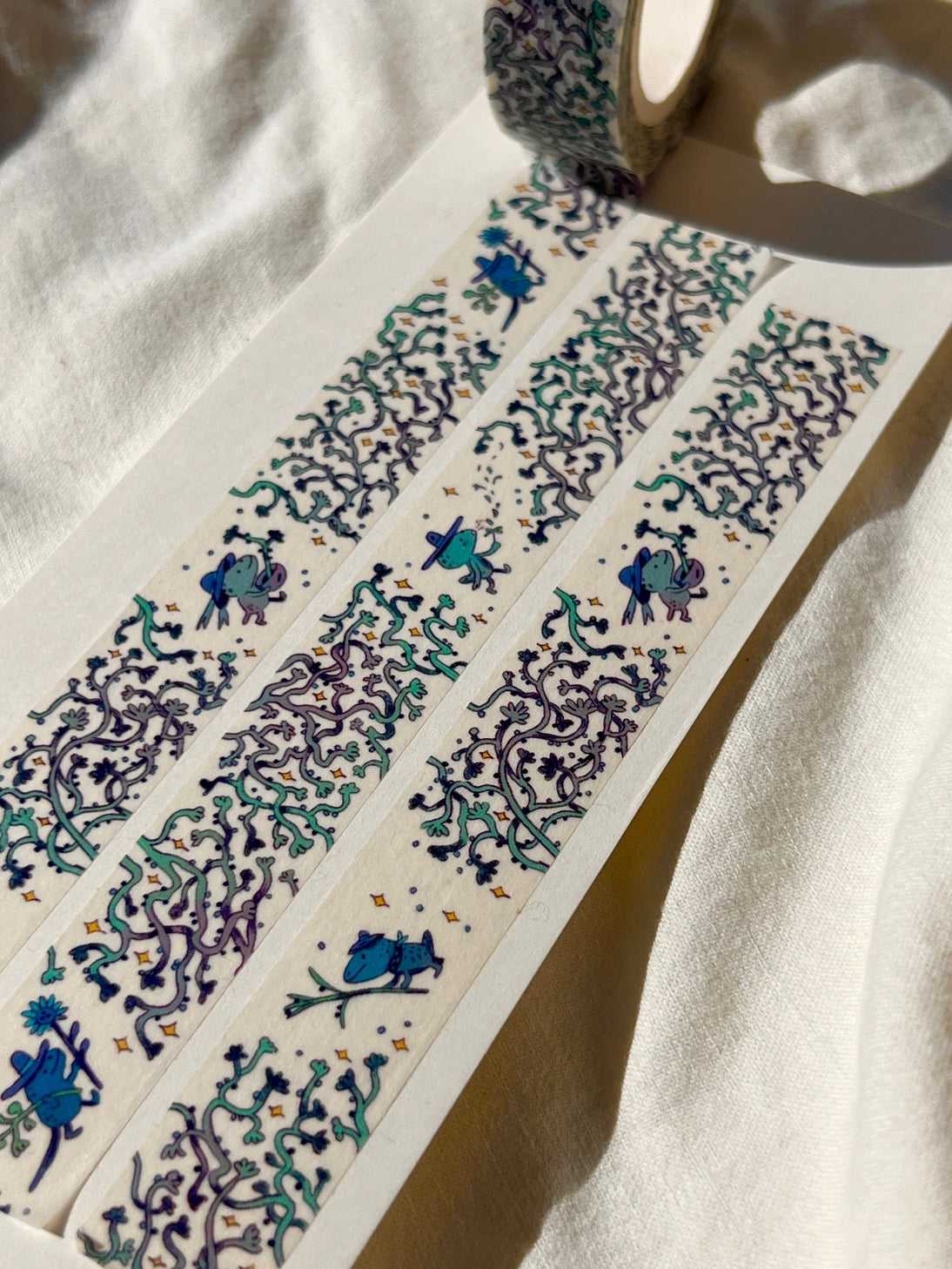 This washi tape features three little blue gardeners who work to keep the vines at bay.
This roll is 15mm wide x 10m of paper tape. Washi tape is super durable and flexible. It tears easily and can be safely applied to a variety of surfaces; it doesn’t leave a sticky residue behind, making it especially ideal for stationery and hanging prints temporarily.