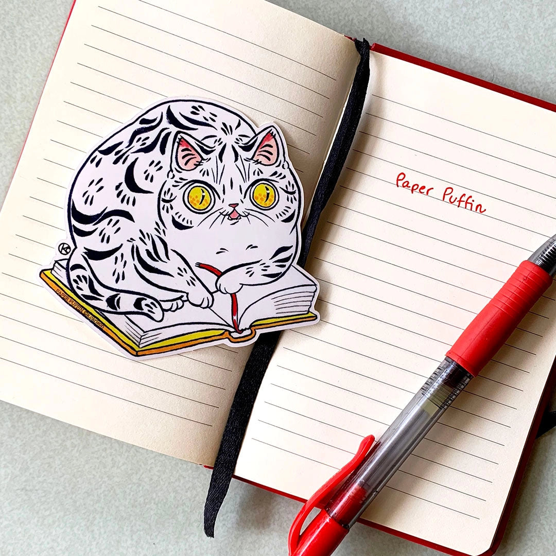 A cat sitting on a favorite book, helping you keep your spot.
+ size:3.3" x 3.4”
+ permanent adhesive glossy vinyl sticker with solid peel backing
+ scratch and weather resistant material, PVC free
+ packaged and shipped flat
All work and photos ©PAPER PUFFIN Art by. K.CARLSON