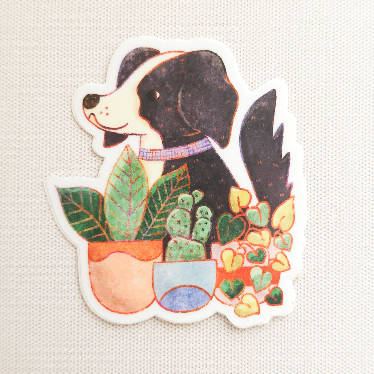 A loyal dog settles in among leafy houseplants, content to rest where sunlight filters softly through the greenery. This vinyl sticker captures that familiar, cozy moment, adding a quiet sense of companionship to your everyday essentials.
Made from durable, waterproof vinyl, this sticker is designed to hold up wherever you place it—whether that’s a water bottle, laptop, or journal you reach for daily.