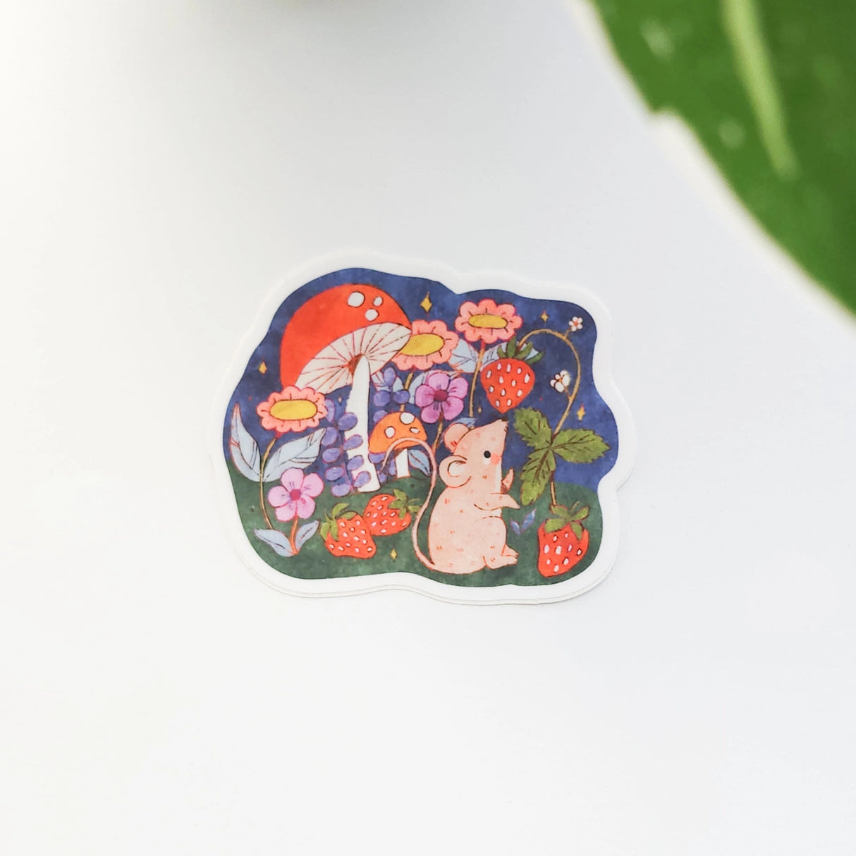 A cheerful little mouse pauses along a sunny garden path in Wildflower Woods, holding a ripe strawberry close before continuing on its way. This vinyl sticker captures that small, joyful moment, celebrating the simple pleasures tucked into everyday life.
Made from durable, waterproof vinyl, this sticker is designed to hold up wherever you place it—whether that’s a water bottle, laptop, or journal you reach for daily.