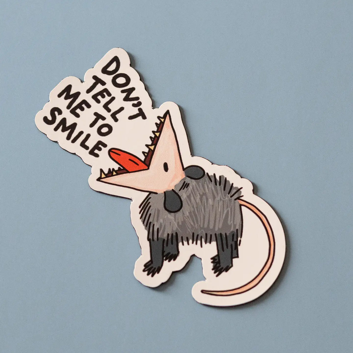A grumpy opossum saying what we’re all thinking: “Don’t Tell Me to Smile.” This bold, sarcastic design is perfect for setting boundaries with humor and zero apologies.
🌟 Key Features:
• Dimensions: 3 x 3 inches
• High-quality vinyl material
• Waterproof and weather-resistant
• Ideal for personalizing any surface