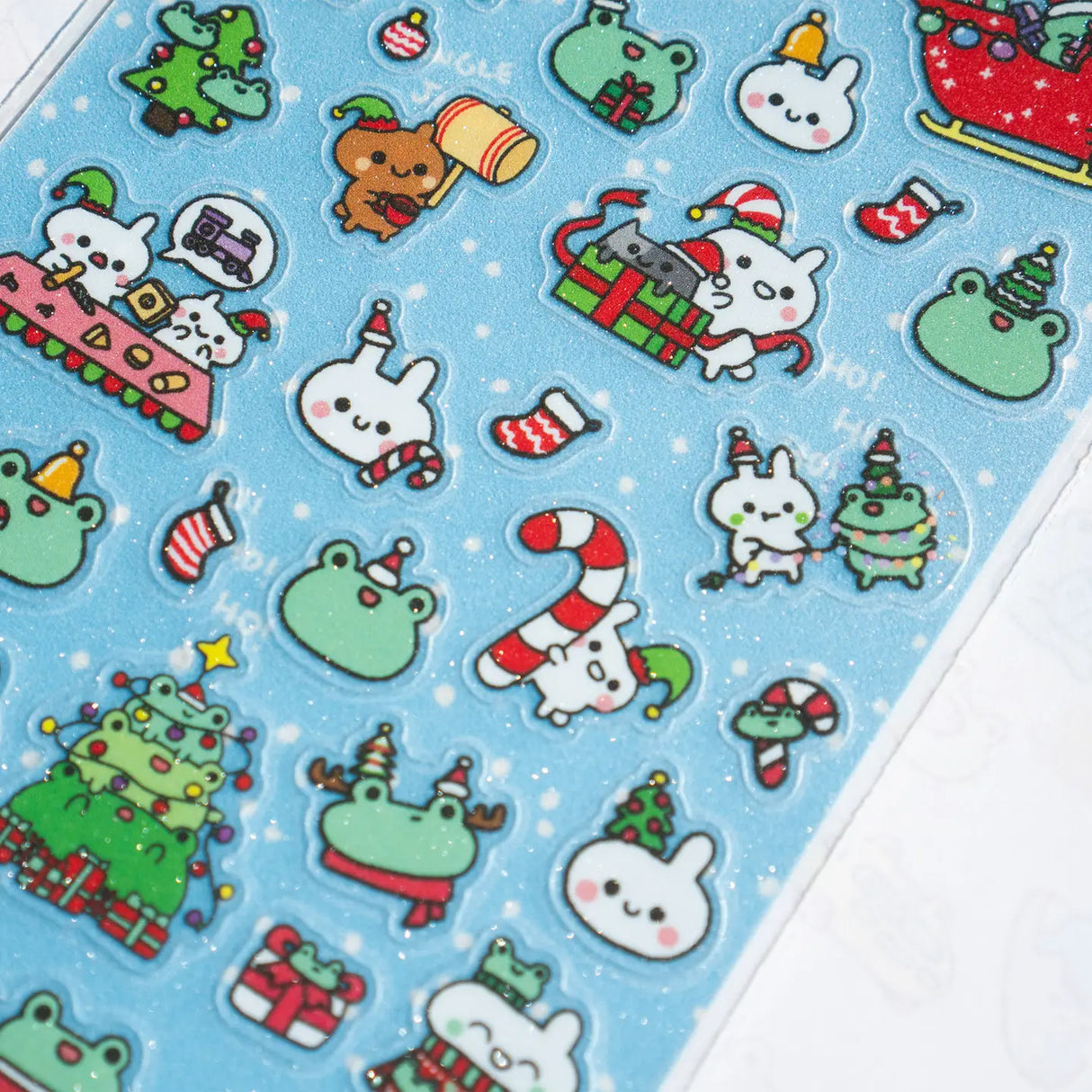 This is part of a new series of sticker sheets that feature different "days".
There are 33 individual glitter stickers on the sheet full of holiday joy!
They are plastic stickers on a frosted plastic sheet with a backing card and packaging that's ready to display.