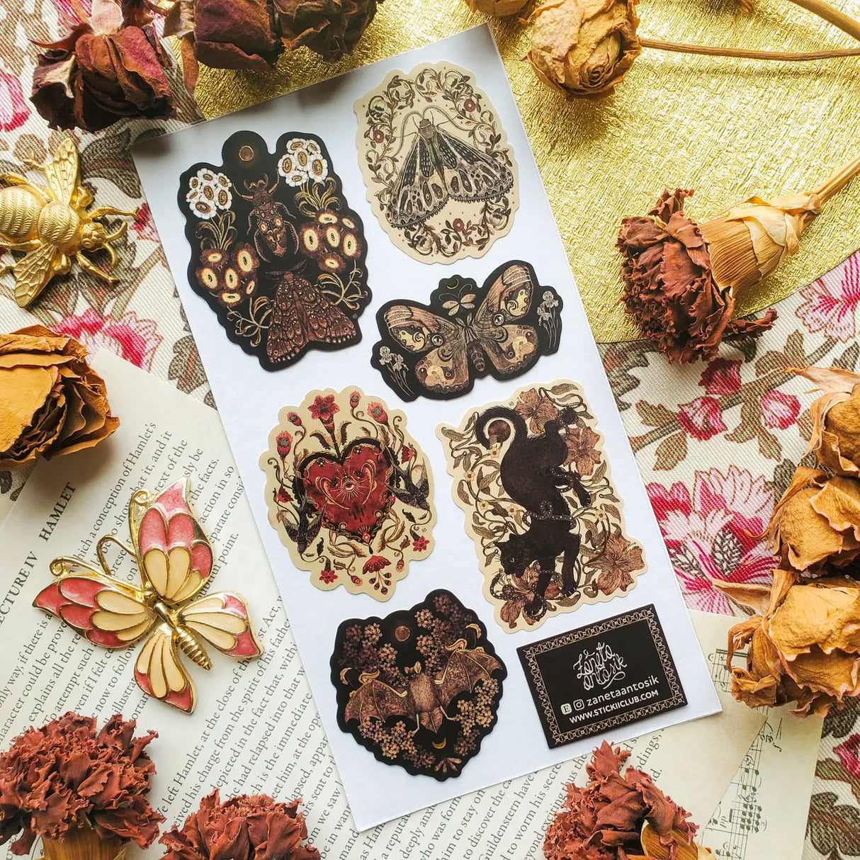 🌙🪲 In this twilight garden by @zanetaantosik, moths, beetles, and shadowy creatures bloom among ornate florals and eclipsed moons. A black cat prowls through curling vines, velvet wings unfurl, and a bat drifts silently across shadowed blossoms — each creature a guardian of this enchanted realm. Perfect for those who find wonder in the dark and poetry in the wild. Art by: @zanetaantosik
Top Coating: Gold Foil
Adhesive Layer: Paper
Backing Layer: Paper
6.69" x 3.54".
Weight - 0.03lbs.
1 sheet included &nb