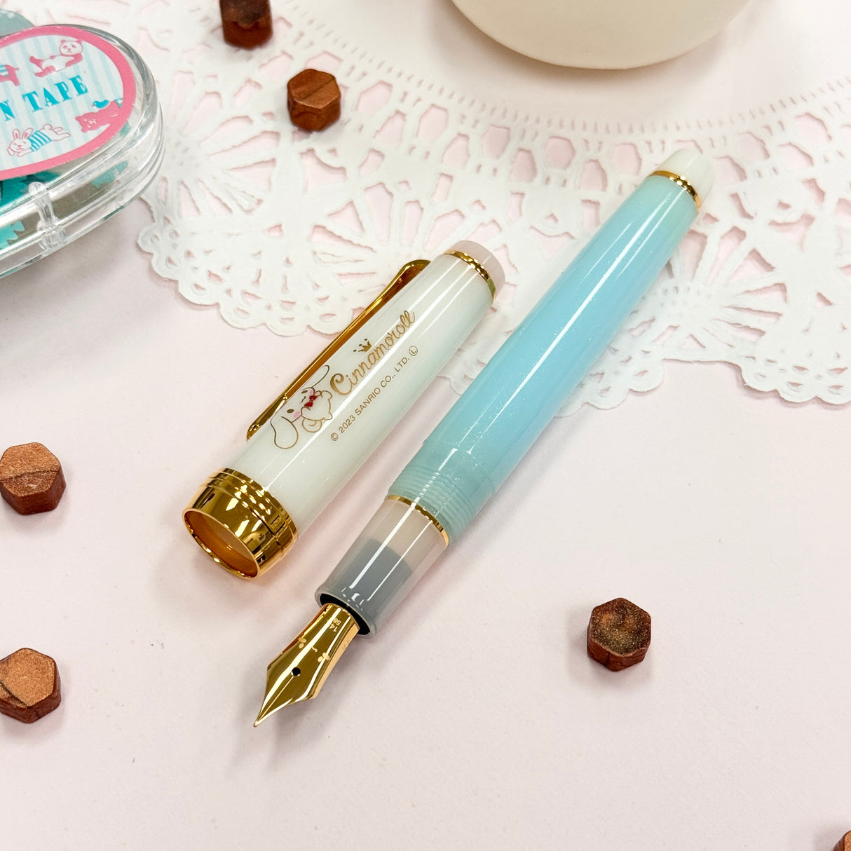 Sailor Limited Edition Professional Gear Slim Fountain Pen - Cinnamoroll
Discover a charming collaboration between Sailor Fountain Pen and Sanrio’s beloved character, Cinnamoroll! This limited-edition fountain pen captures the elegant and adorable world of Cinnamoroll, featuring luxurious gold accents on the clip and ring, along with special Cinnamoroll logo motifs on the cap, finial, and nib. The 14k gold nib is beautifully engraved with Cinnamoroll’s face, adding a delightful touch to this unique wr