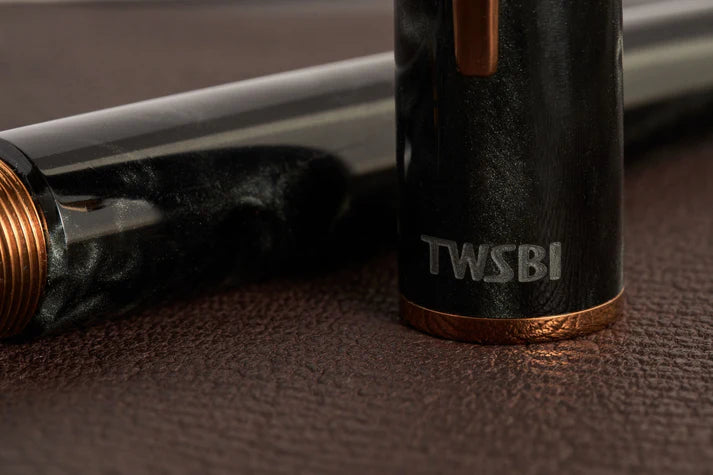 This TWSBI Obsidian fountain pen is made of a dark grey/black swirled acrylic resin, inspired by the natural obsidian stone. The pen is complemented by rose gold-plated trim and is equipped with a rose gold-plated stainless-steel nib.
Pen cap is able to post onto the back of the pen
Piston Filler Fountain pen.
Simply unscrew the end cap, dip into ink, screw back the end cap, and you're done! Ready to write!!