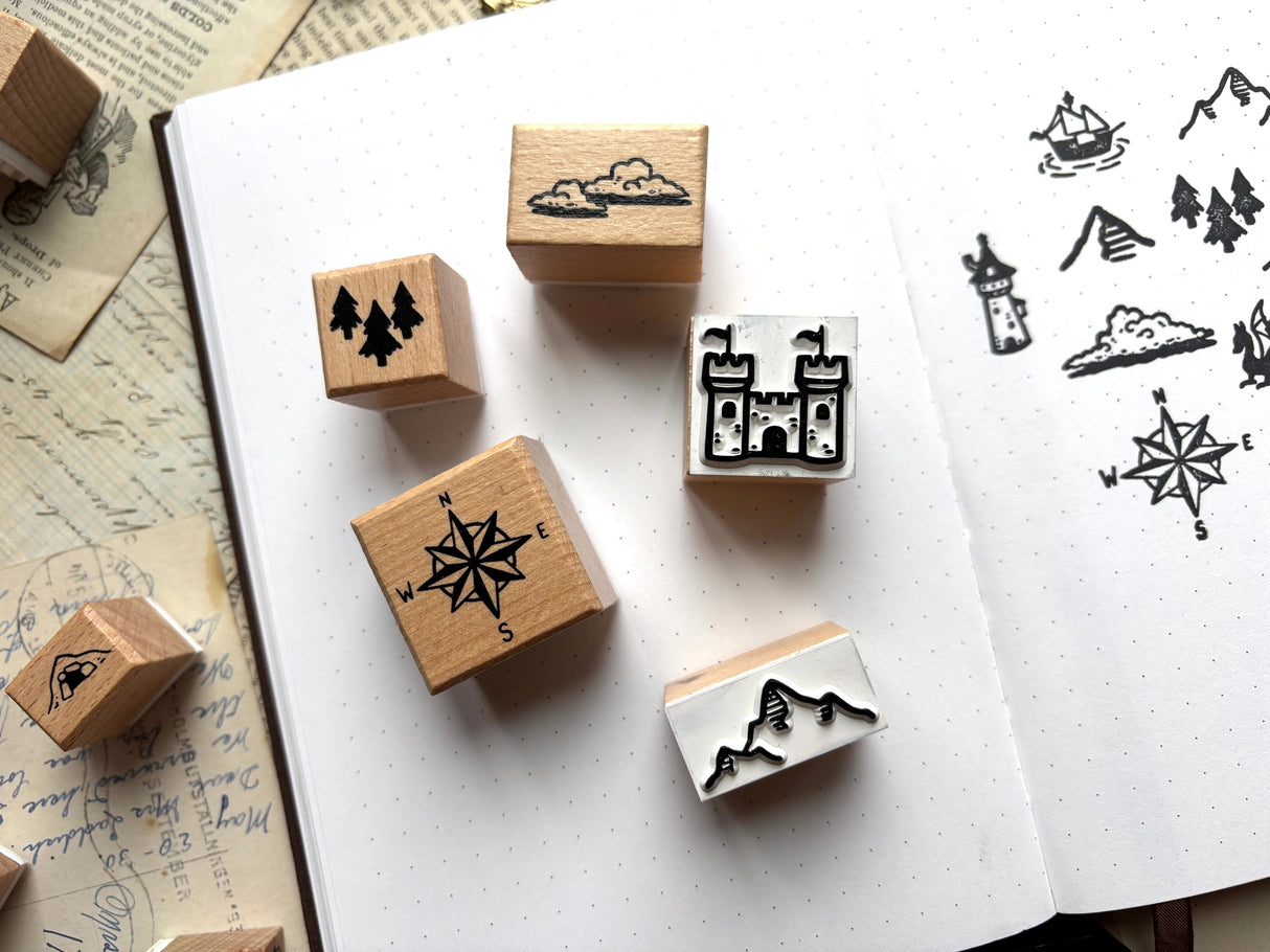 One set of 16 rubber stamps to DIY your own maps! Use this for brainstorming that next epic fantasy, or to keep track of locations in your ttrpg campaign. Stamps range in size from 10x10 to 30x30mm, and are each 24mm tall. The set will come packed in a cute little paper drawer box.