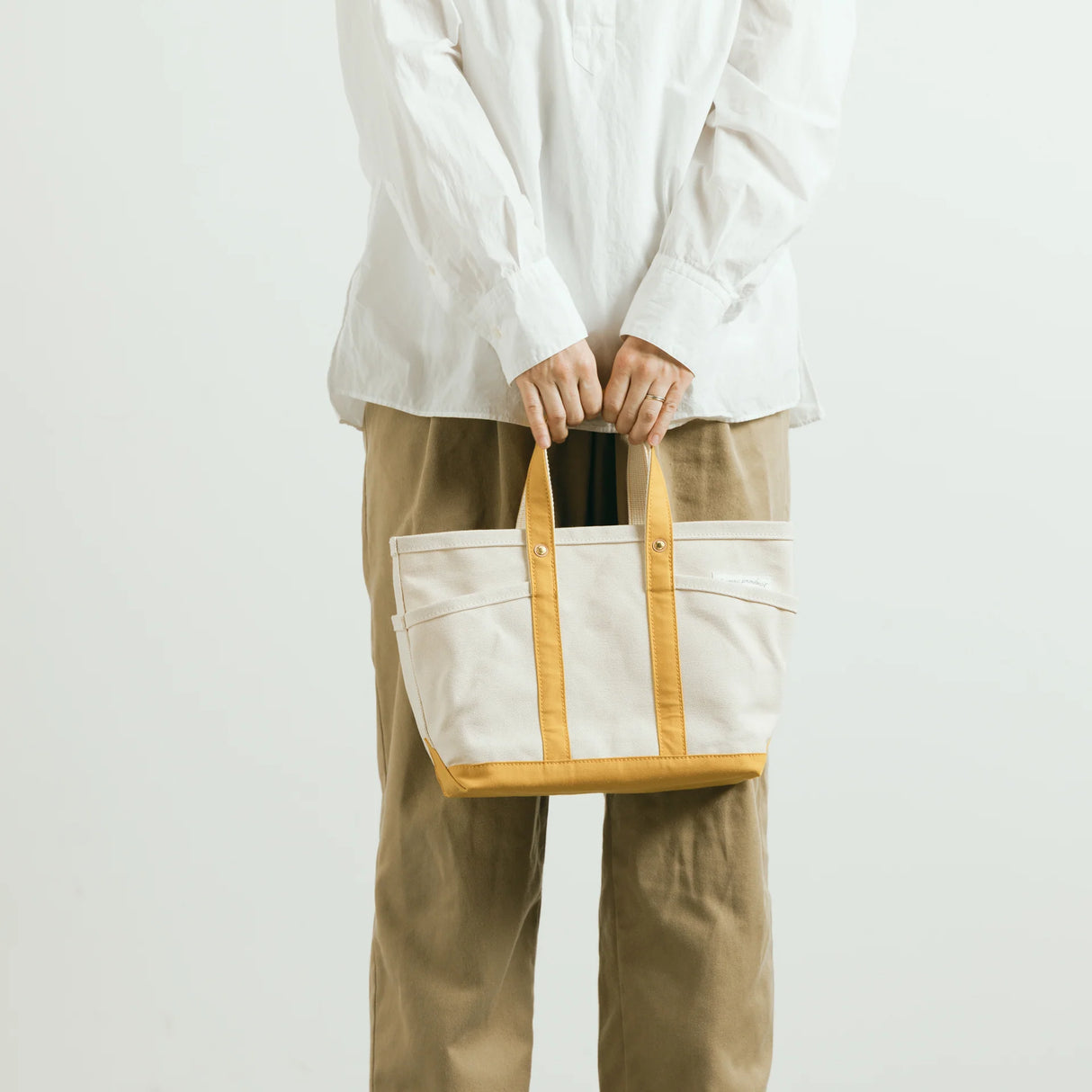 The SUPERIOR LABOR Mini Tote Bag
A simple, timeless canvas bag designed for everyday life.
Its compact size is just right for daily essentials, while the four outer pockets keep your glasses, keys, favorite pens, or notebook neatly organized.
They make it easy to stay tidy and add a touch of extra storage without changing the clean look of the bag.
Size: W37×H23.5×D12.5cm
Canvas Products
Painted areas may be affected by friction or water, which can cause color transfer. Please handle with care.