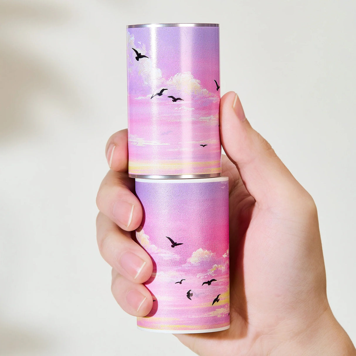 Capture the gentle embrace of evening with the Lotus Twilight Wide Washi/PET Tape. This tape embodies the softest part of the sunset. The design features a dreamy, seamless gradient that flows from a warm, glowing orange into a hazy, light lavender. Drifting through this pastel sky is a flock of silhouetted birds, gliding peacefully on the breeze. It brings a sense of calm and whimsy to your journal, perfectly replicating that quiet, cotton-candy sky moment just before the stars come out.