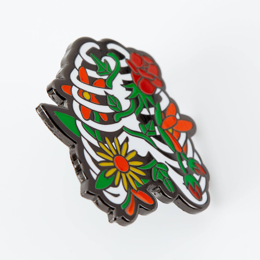 Pin de esmalte con diseño floral de caja torácica