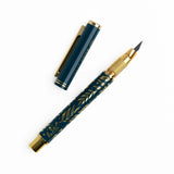 A beautifully designed craft knife featuring a deep teal barrel adorned with gold botanical detailing. With its precision blade and sturdy metal construction, this tool brings both function and elegance to journaling, scrapbooking, and detailed paper crafting.

Specs &amp; Details:

Material: Metal body with gold accents
Design Theme: Teal barrel with gold botanical illustration
Blade: Precision craft blade (replaceable)
Features: Removable cap for safe storage, textured grip for control
Use: Ideal for cutt
