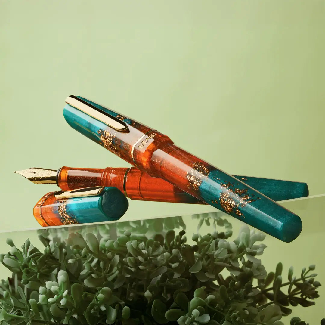 BENU presents the newest Haute Collection — a line of elegant, fashion-inspired pens that blend classic charm with bold, modern flair. The designs include both subtle and vibrant styles, showcasing BENU’s signature glitter and color artistry. Each pen features a faceted body with alternating wide and slender facets, complemented by either gold-plated or chrome-plated trims for a sleek, timeless look.

With a bold orange and teal body streaked with gold, Chic turns heads with runway-ready style. Fashion-forw