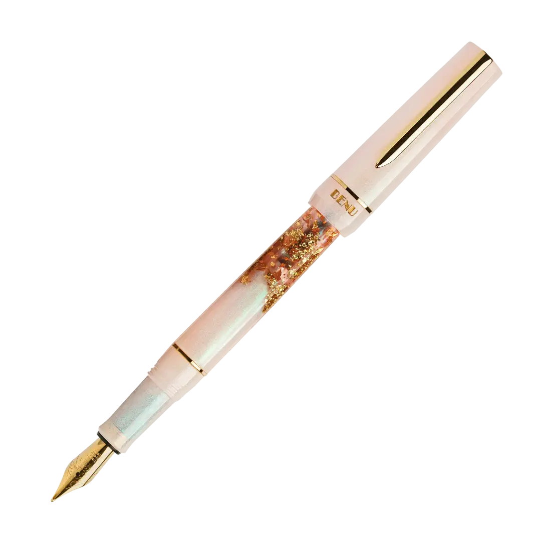BENU presents the newest Haute Collection — a line of elegant, fashion-inspired pens that blend classic charm with bold, modern flair. The designs include both subtle and vibrant styles, showcasing BENU’s signature glitter and color artistry. Each pen features a faceted body with alternating wide and slender facets, complemented by either gold-plated or chrome-plated trims for a sleek, timeless look.

A mix of golden flakes dances through a soft, pearly pink base, complemented by gleaming gold trim. Tender 