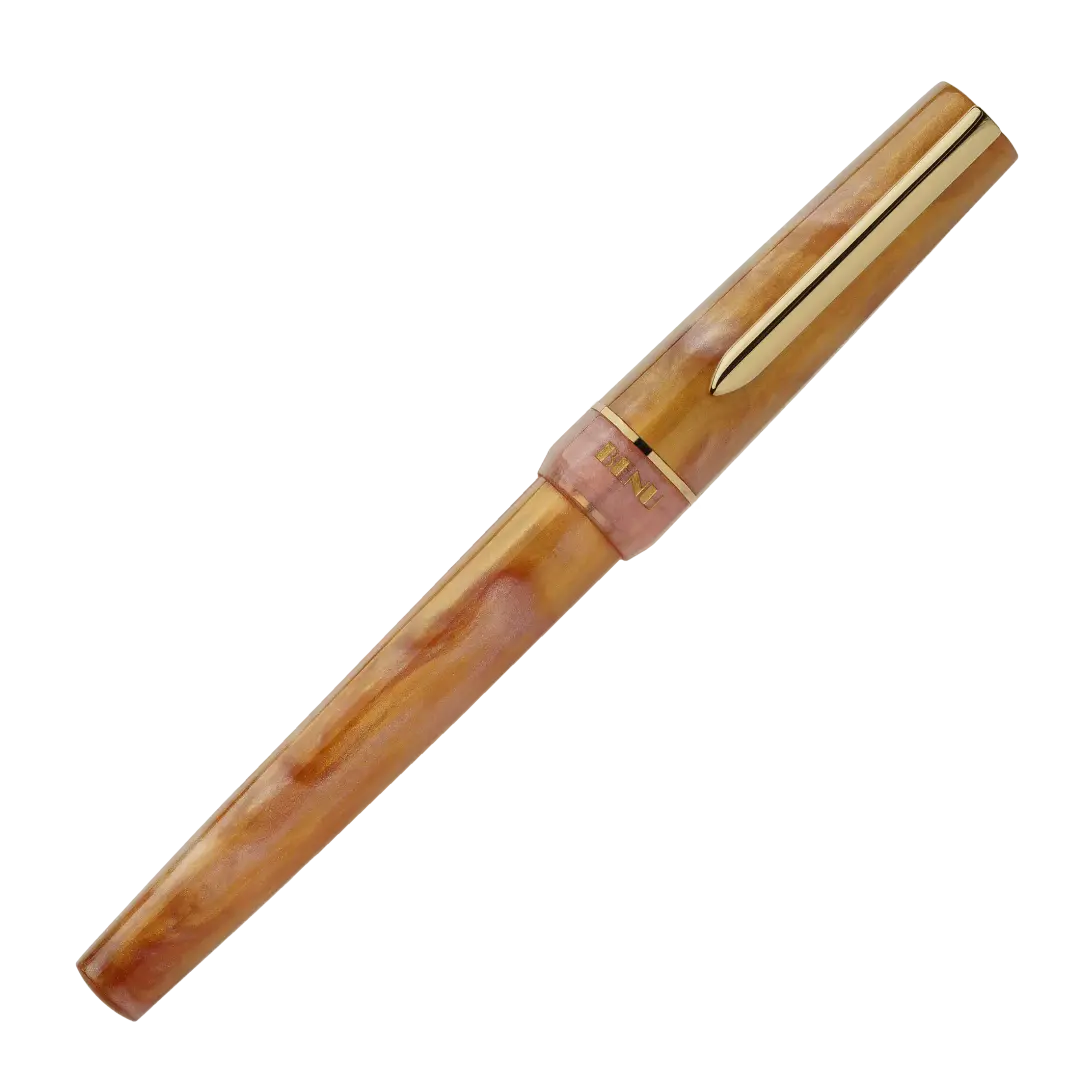 BENU presents the newest Haute Collection — a line of elegant, fashion-inspired pens that blend classic charm with bold, modern flair. The designs include both subtle and vibrant styles, showcasing BENU’s signature glitter and color artistry. Each pen features a faceted body with alternating wide and slender facets, complemented by either gold-plated or chrome-plated trims for a sleek, timeless look.

Lustre pen glows with warm swirls of amber and blush, finished in radiant gold trim.Quietly luxurious, Lust