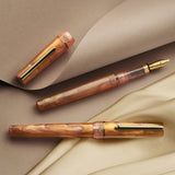 BENU presents the newest Haute Collection — a line of elegant, fashion-inspired pens that blend classic charm with bold, modern flair. The designs include both subtle and vibrant styles, showcasing BENU’s signature glitter and color artistry. Each pen features a faceted body with alternating wide and slender facets, complemented by either gold-plated or chrome-plated trims for a sleek, timeless look.

Lustre pen glows with warm swirls of amber and blush, finished in radiant gold trim.Quietly luxurious, Lust