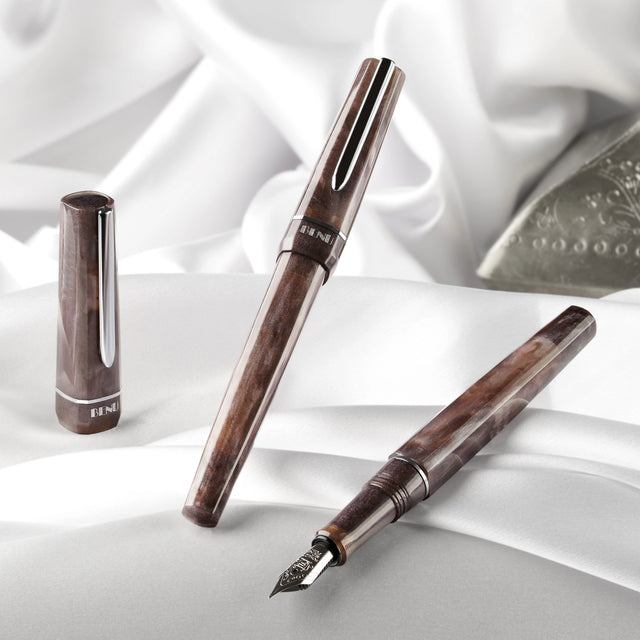 BENU presents the newest Haute Collection — a line of elegant, fashion-inspired pens that blend classic charm with bold, modern flair. The designs include both subtle and vibrant styles, showcasing BENU’s signature glitter and color artistry. Each pen features a faceted body with alternating wide and slender facets, complemented by either gold-plated or chrome-plated trims for a sleek, timeless look.

With smoky gray marbling and polished chrome hardware, Satin is the essence of modern elegance. Understated