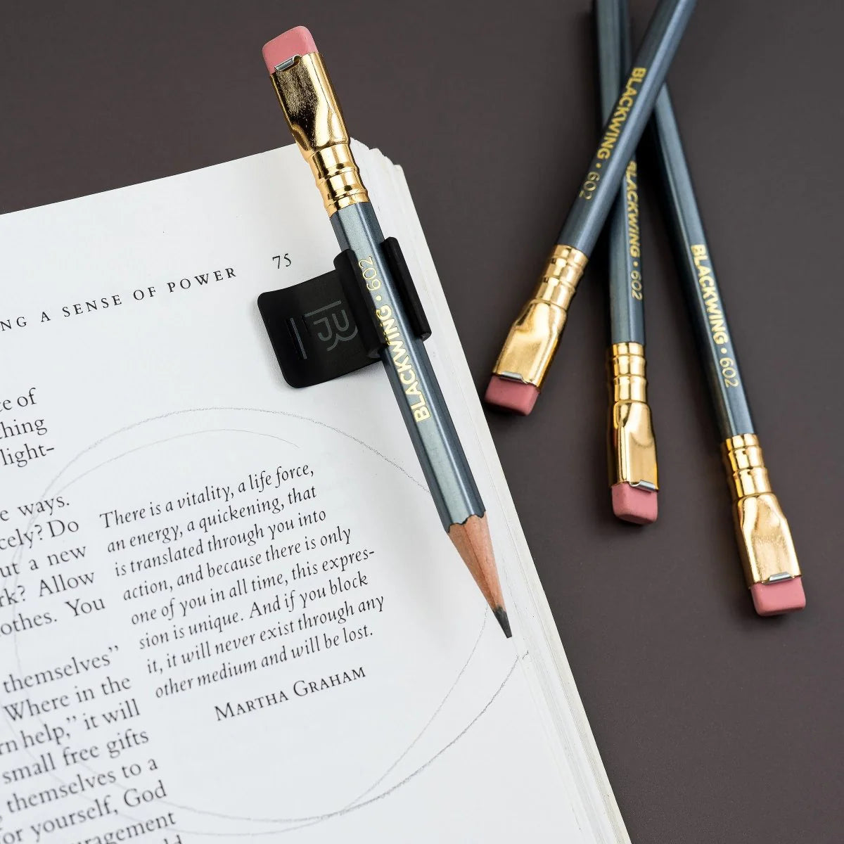 The Blackwing Notebook Clip is designed to keep your pencil and paper together. The clip is made of aluminum and finished with our signature matte black texture. Once you attach the reusable clip to your notebook, your pencil snaps into a durable thermoplastic polymer that won't scuff the lacquer. Perfect for everyday carry—clip it onto your spiral notebook, legal pad, memo book, or reading book to keep your stationery organized.