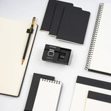 The Blackwing Notebook Clip is designed to keep your pencil and paper together. The clip is made of aluminum and finished with our signature matte black texture. Once you attach the reusable clip to your notebook, your pencil snaps into a durable thermoplastic polymer that won't scuff the lacquer. Perfect for everyday carry—clip it onto your spiral notebook, legal pad, memo book, or reading book to keep your stationery organized.