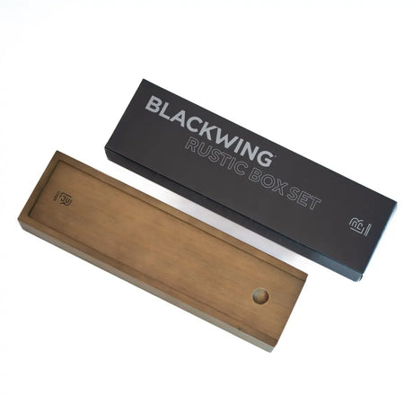 The Blackwing Rustic Box features your choice of 12 premium Blackwing graphite pencils and our reliable Two-Step Long Point Sharpener. Choose from 12 Matte pencils,12 602 pencils, 12 Pearl pencils, 12 Natural pencils, or 3 of each. The aged pine pencil box slides open to reveal the Blackwing pencils and a black cork-lined interior. The smooth stationery box is perfect for any workspace, office, or desk.

All Rustic Boxes now come with our Grey Two-Step Long Point Sharpener.

All Blackwing pencil products co