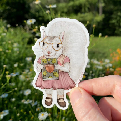 This white squirrel is so happy that the used bookstore had the title she was looking for. Even better: it's a signed first edition!

This die-cut gloss vinyl sticker is durable, weatherproof, and perfect for water bottles, notebooks, laptops, bikes, and all sorts of other surfaces! Make sure to clean and dry the surface thoroughly before applying.