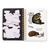 Dumpster chic meets unapologetic attitude in the Trash Bandits Sticker Book—a gloriously messy collection of oversized stickers featuring raccoons, possums, pigeons, and other urban icons with googly eyes and snarky commentary. Whether you're decorating your planner or marking your territory, these critters are here to add some trashy charm to your everyday life.

Inside, you’ll find 18 pages of trash animal stickers + 2 bonus pages of vintage-inspired puffy stickers, all packed with clever quips and chaoti
