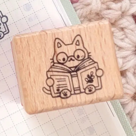A small wood stamp of a little literary kitty for your planner and scrapbooking needs. Each stamp measures approximately 1 x 0.75 inch.

Stamps come loose and without any extra packaging.
