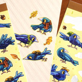 A bunch of crows with various accessories. Some backpacks, scarves and hats! 8 Total large stickers, and 6 smaller stickers.

Waterproof vinyl sticker sheet, 5"x7"
14 peelable stickers per sheet
Durable and high quality
Packaged in a clear plastic sleeve