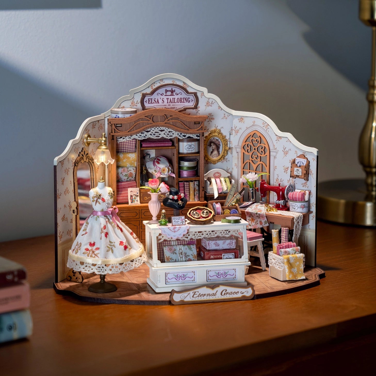 Immerse yourself in the delicate artistry of tailoring with this exquisite DIY miniature kit. Featuring finely crafted rolls of fabric, graceful ribbons, and an elegant dress poised upon a classic dress form, this kit invites you to create a sophisticated and enchanting tailor's room. Perfect for those who appreciate intricate craftsmanship, it beautifully captures the timeless charm of a bespoke workspace in miniature.

2 AAA batteries required; batteries are not included.
Ages 14+
322 pieces&nbsp;
Assembl