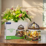 Step into a tranquil garden escape with this miniature kit-a sun-drenched sanctuary filled with flourishing plants, rustic charm, and peaceful vibes. This beautifully crafted greenhouse-style gazebo features delicate woodwork, glass-like panels, and an inviting open-air design surrounded by vibrant flowers, climbing vines, and cozy garden furniture. Whether you're dreaming of a relaxing afternoon under the sun or a quiet place to sip tea and tend to your plants, this miniature brings that dream to life-one 
