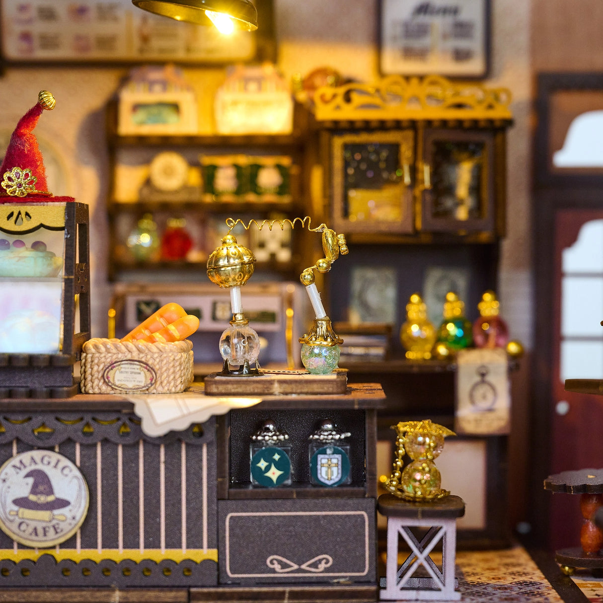 Step into a whimsical world of sugar, spells, and stardust with the Magic Café DIY Miniature House Kit. This enchanting build-it-yourself café brings to life a cozy little corner where witches, wizards, and woodland creatures gather for enchanted brews and magically infused pastries. Watch as tiny shelves fill with jars of mysterious ingredients, and the glass display case glows with cakes that sparkle with edible enchantments.

2 AAA batteries required; batteries are not included.
Ages 14+ 380 pieces
Assem