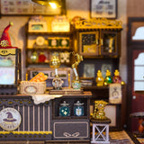 Step into a whimsical world of sugar, spells, and stardust with the Magic Café DIY Miniature House Kit. This enchanting build-it-yourself café brings to life a cozy little corner where witches, wizards, and woodland creatures gather for enchanted brews and magically infused pastries. Watch as tiny shelves fill with jars of mysterious ingredients, and the glass display case glows with cakes that sparkle with edible enchantments.

2 AAA batteries required; batteries are not included.
Ages 14+ 380 pieces
Assem