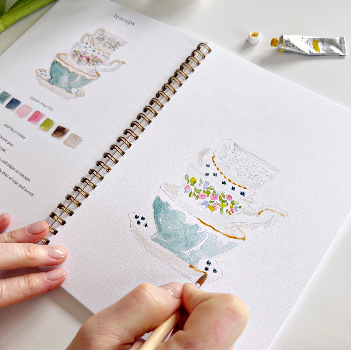 Twelve spring illustrations — a bunny, baby chick, tulips, lilacs, an Easter basket, a bicycle with flowers, and more — each pre-outlined with step-by-step instructions. Paintings take about thirty minutes from start to finish, making it approachable for first-time painters and a favorite for gifting.

Enjoy this peaceful painting hobby on your own, with children, or with friends. Makes a wonderful gift and is perfect for artists of any age.
Details:

12 beginner-friendly illustrations
Thick 120lb watercolo