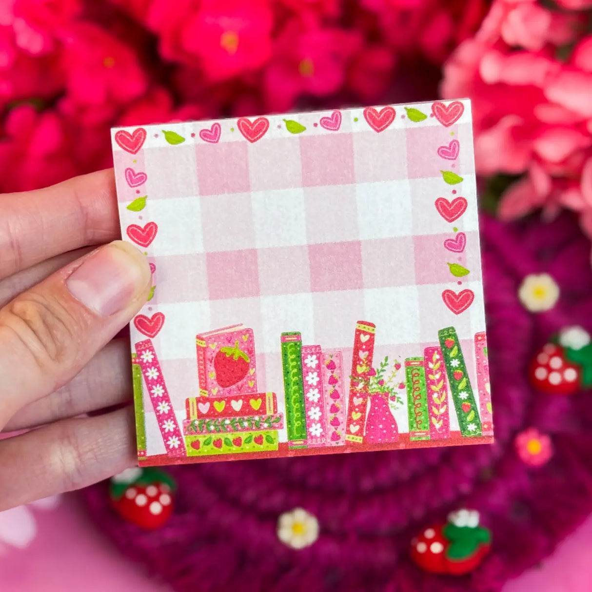 Stay organized in style with this adorable Strawberry Bookshelf Notepad! Perfect for jotting down your daily tasks, goals, and bookish ideas, this notepads brings a pop of personality to your desk. Featuring a sturdy cardboard back and premium 70lb. uncoated paper, it's built to last through all your planning adventures.&nbsp;

✦ DETAILS ✦

Size: 3" x 3"
70 lb. Paper Uncoated

Padded With Cardboard Back

50 Sheets
No magnet backing