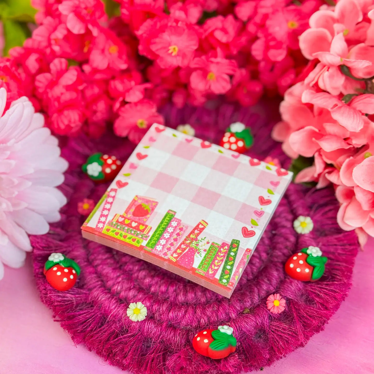 Stay organized in style with this adorable Strawberry Bookshelf Notepad! Perfect for jotting down your daily tasks, goals, and bookish ideas, this notepads brings a pop of personality to your desk. Featuring a sturdy cardboard back and premium 70lb. uncoated paper, it's built to last through all your planning adventures.&nbsp;

✦ DETAILS ✦

Size: 3" x 3"
70 lb. Paper Uncoated

Padded With Cardboard Back

50 Sheets
No magnet backing