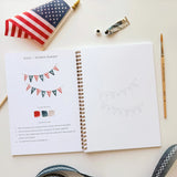 Twelve illustrations of flags, stars, and classic summer scenes — each pre-outlined with step-by-step instructions. Paintings take about thirty minutes from start to finish, making it approachable for first-time painters and a favorite for gifting.

A timely release for America's 250th anniversary in 2026. A strong May–July seller and a natural fit for home, gift, and patriotic-themed boutiques.

12 beginner-friendly illustrations
Thick 120lb watercolor paper&nbsp;
Lay-flat pages with spiral binding for has