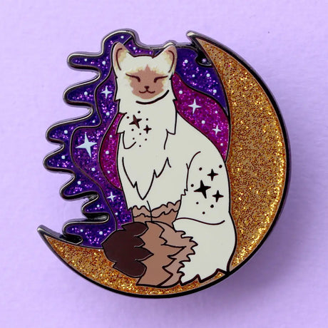 Calling all owners of a long haired pointed / meezer cats! This super cute design features the cat sitting in front of a sparkly moon with a glittery, starry sky in the background.

The pin is 40mm (1.57”) tall, and is made from gunmetal hard enamel, with glitter and UV printed details. It's secured with 2 pink clutches to keep the pin in place.