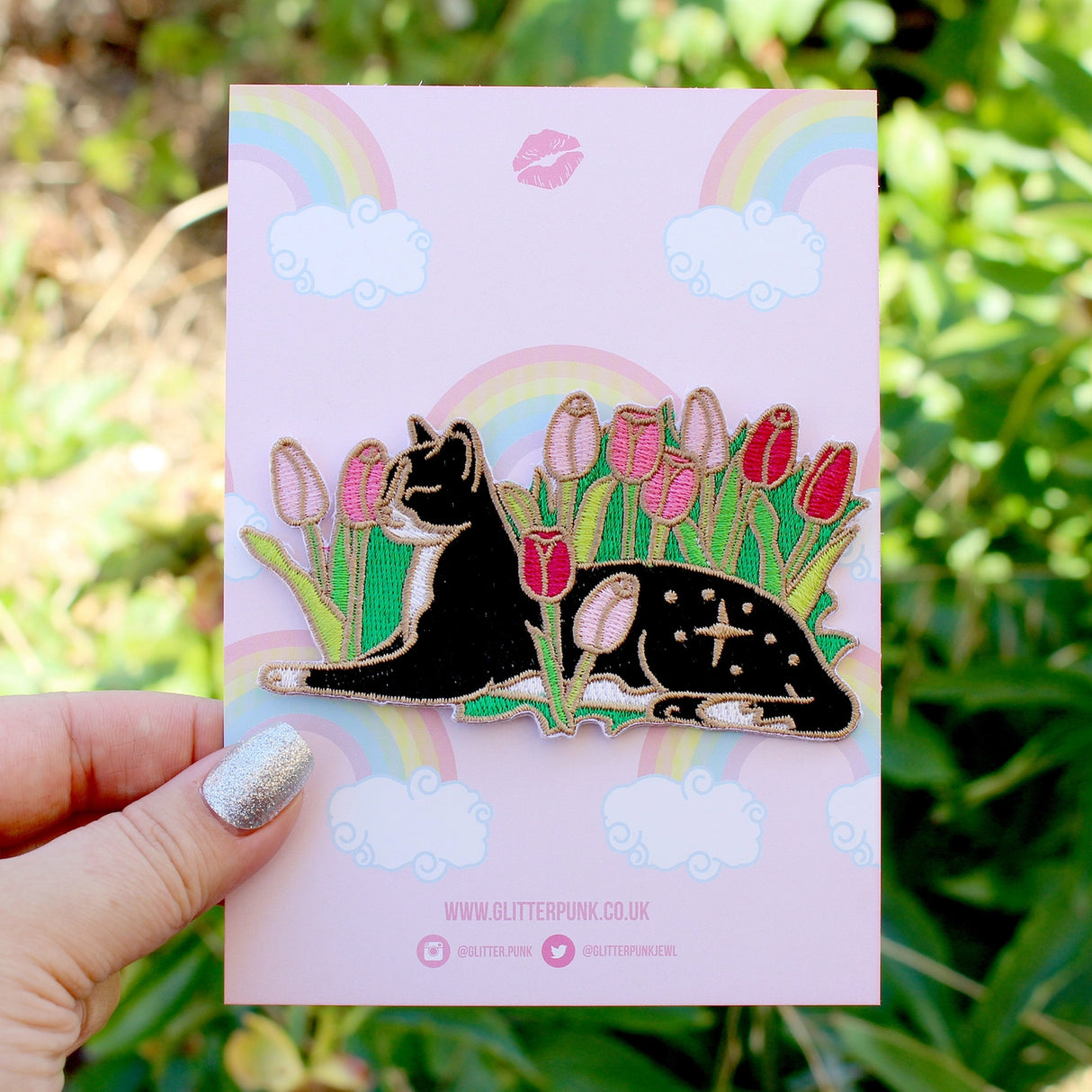 Cats love nothing better than relaxing in a flower bed – and this cute cat is no exception! This awesome embroidered patch features a black and white tuxedo cat lying down in some pink tulips.

Beautifully woven with black, white, pink, green and gold threads, this fabulous patch with brighten up any coat, bag or hat!

Measurements: 100mm wide