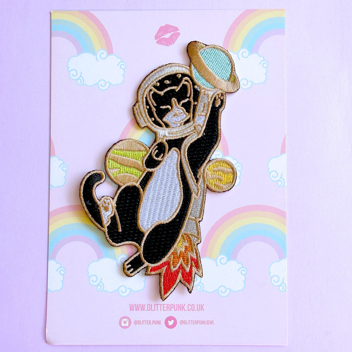 This awesome Astronaut Cat patch features a tuxedo cat with a helmet and rocket ship playing with some planets.

Beautifully woven with multi coloured threads, this fabulous patch with brighten up any coat, bag or hat!

Measurements: 64mm x 110mm