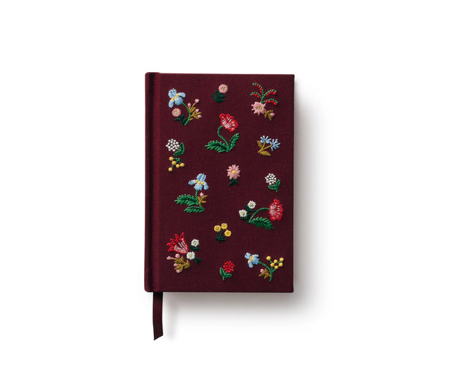 A mini hardcover journal, embroidered with delicate Gracie blooms and gold accents. Inside, find 240 blank, unlined pages and a ribbon bookmark.