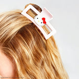 A playfully pink clip featuring Hello Kitty and her iconic red bow, perfect for adding her signature sweetness to your hairstyle.

Great for half-up styles, buns, and everyday updos. Lightweight, durable, and easy to wear!
